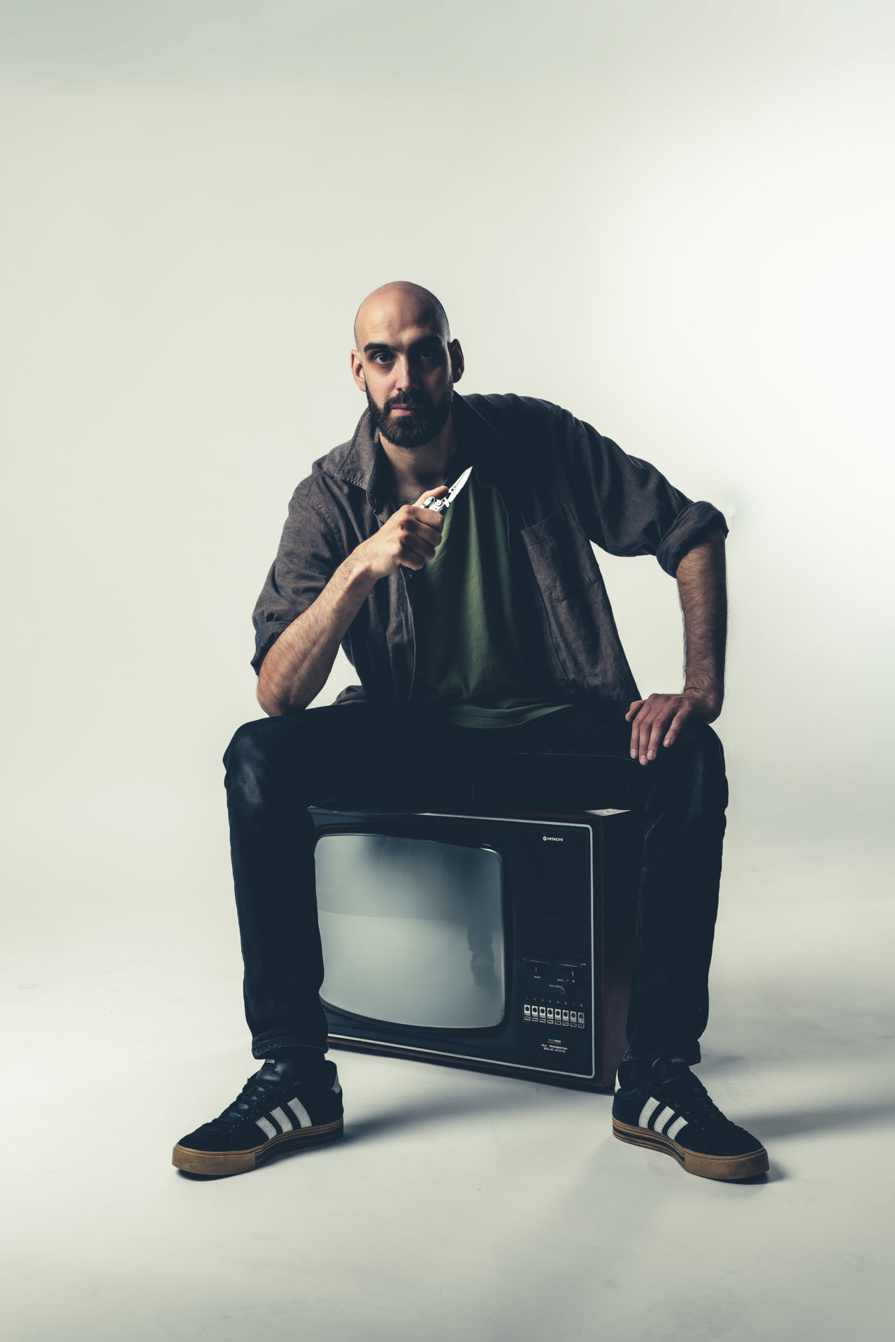 Vincent Guidoux assis sur une télévision rétro, penché en avant