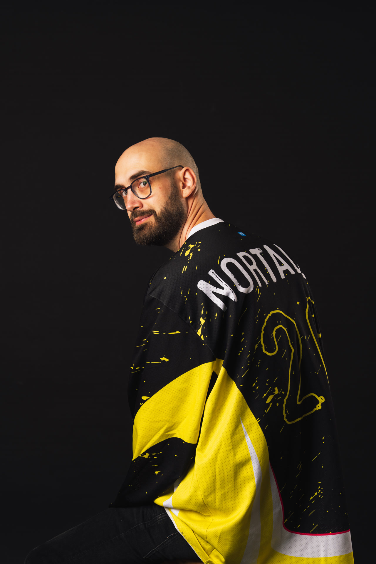 Vincent Guidoux assis sur une télévision rétro, au téléphone