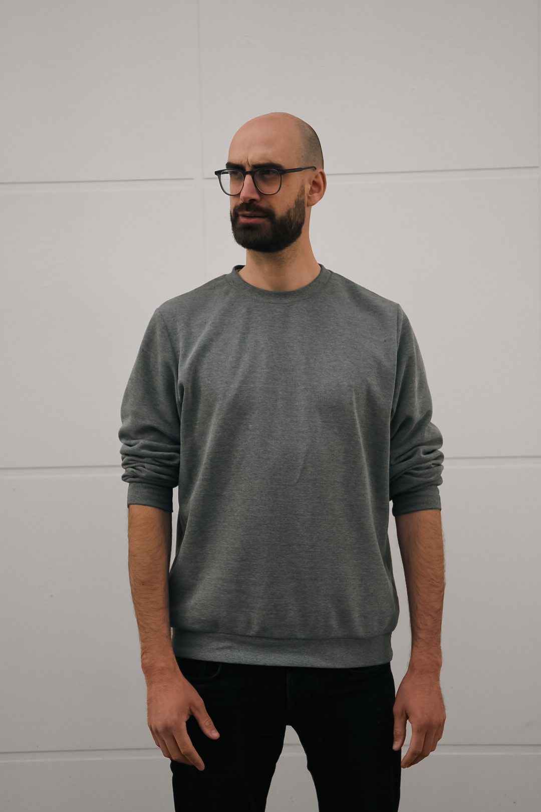 Vincent Guidoux debout, pull gris, regard de côté
